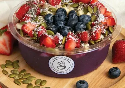 a salad in a plastic container with strawberries and blueberries at Kiatthada Resort in Bangkok