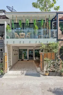 a building with a patio with chairs and plants at Thai wabi-sabi Loft in Bangkok