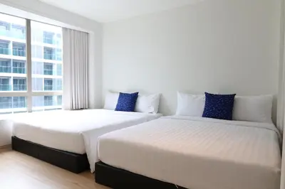 two beds in a room with a large window at Casa del Toro in Bangkok
