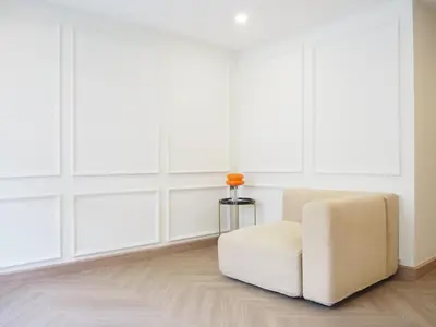 a white chair in a room with white walls at Casa del Toro in Bangkok