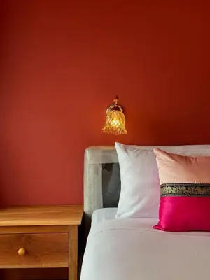 a bedroom with a bed with a pink pillow and a lamp at Cha Na Stay at Merry V in Bangkok