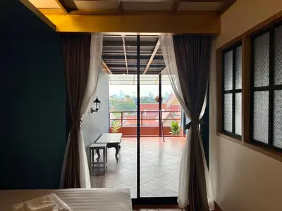 a bedroom with a bed and a view of a patio at Cha Na Stay at Merry V in Bangkok