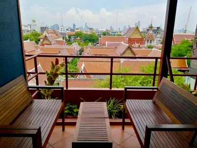 a balcony with two benches and a view of a city at Cha Na Stay at Merry V in Bangkok