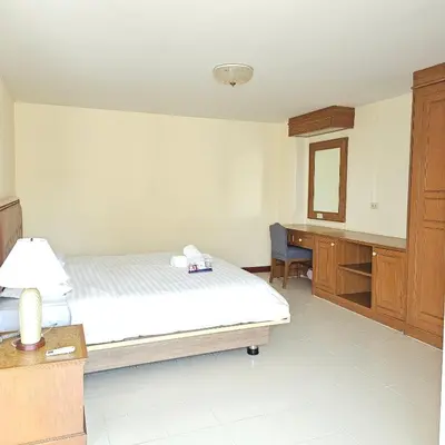 a bedroom with a bed and a desk and a mirror at Omni Suites 2Bedroom in Bangkok