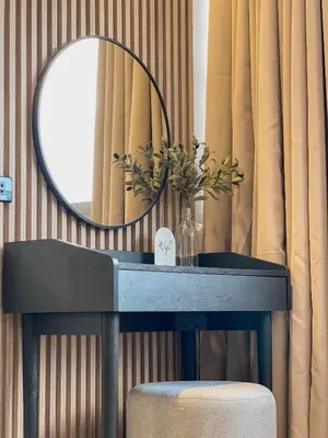 a table with a mirror and a vase with flowers on it at Better Room ห้องพักรายวัน เมืองทองธานี C2 in Nonthaburi