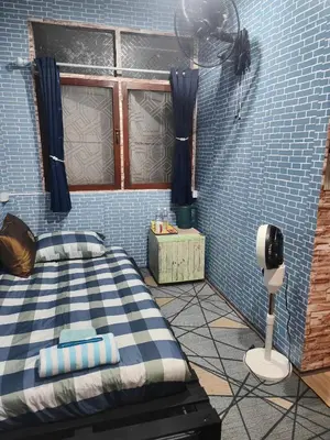 a bedroom with a bed and a fan in a room at 108 Quiet and nice fan apartment with full amenities free Wi-Fi in Bangkok