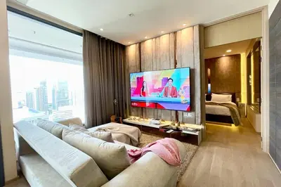 a living room with a couch and a flat screen tv at Ultimate Luxurious in Prime Bangkok Asoke in Bangkok