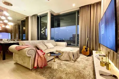 a living room with a couch and a guitar at Ultimate Luxurious in Prime Bangkok Asoke in Bangkok