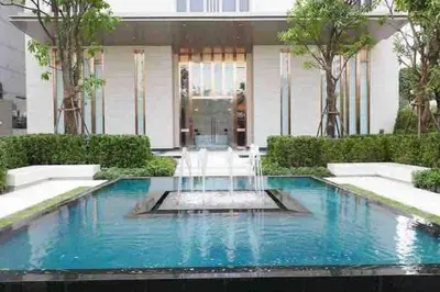 a swimming pool in front of a house at Ultimate Luxurious in Prime Bangkok Asoke in Bangkok