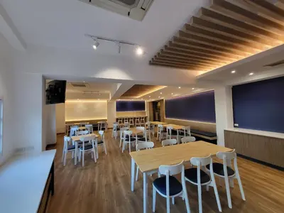 a dining room with tables and white chairs at The Raya Surawong Bangkok in Bangkok