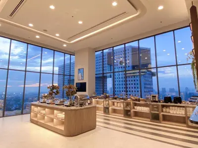 a hotel lobby with a view of the city at The Quarter Ratchayothin by UHG in Bangkok