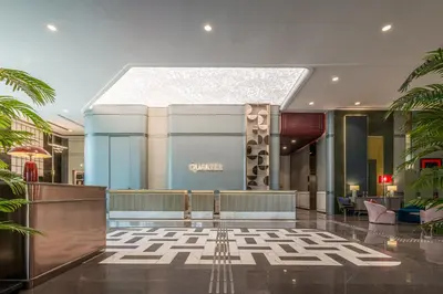 a lobby of a hotel with palm trees at The Quarter Ratchayothin by UHG in Bangkok