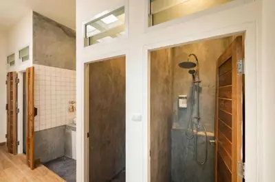 a bathroom with a shower and a glass door at Cape Ratchada. in Bangkok
