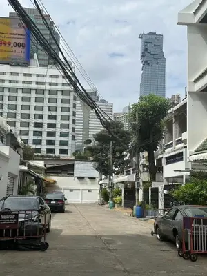 a city street with cars parked in front of buildings at The Cute Silom hostel in Bangkok