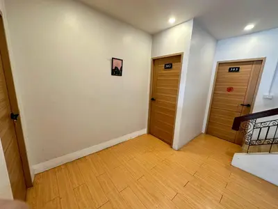 a hallway with two wooden doors and wooden floors at The Cute Silom hostel in Bangkok