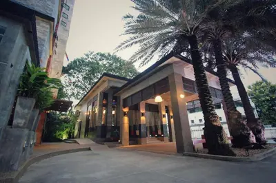 a building with palm trees in front of it at Pak Ping Ing Tang Boutique Hotel in Ban Bang Khen (1)