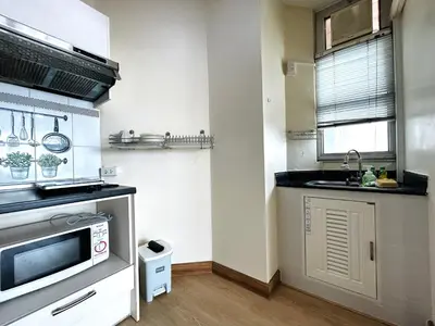 a kitchen with a sink and a microwave at Cozy Victoria Lakeview 5 mins to Impact Muang Thong in Ban Bang Phang