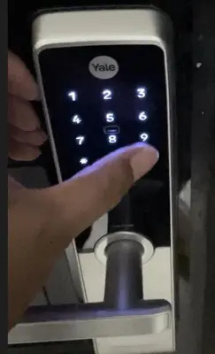 a hand is holding a cell phone with a button at Cozy Victoria Lakeview 5 mins to Impact Muang Thong in Ban Bang Phang