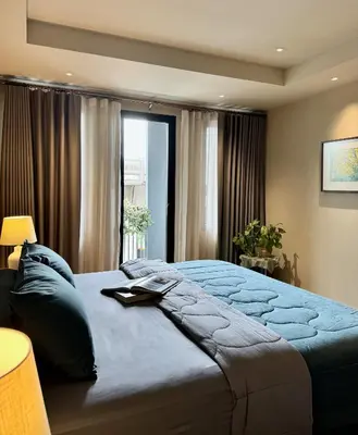 a bedroom with a large bed and a window at Brown's Residence in Bangkok
