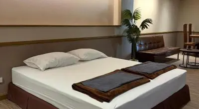 a bedroom with a bed with two towels on it at Alameda Suites Hotel in Bangkok