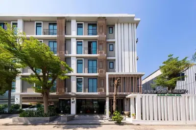 a large white building with trees in front of it at BB House Mini Suite Hotel in Ban Zong Katiam