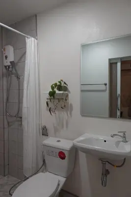 a white bathroom with a toilet and a sink at AboutTime Bangkok in Bangkok