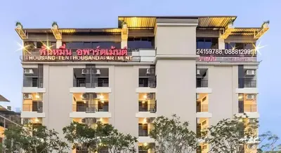 a large white building with a sign on it at THOUSAND-TEN THOUSAND HOTEL in Sathani Wat Sing