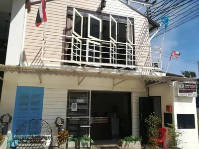 a house with a balcony on top of it at THOUSAND-TEN THOUSAND HOTEL in Sathani Wat Sing