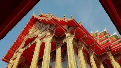 a red and gold building with a blue sky in the background at The Queen Palace in Ban Bang Talat
