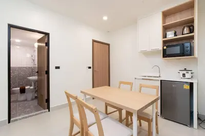 a kitchen and dining room with a wooden table and chairs at Townhouse in Pratunam Bangkok in Bangkok