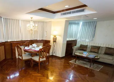 a living room with a table and a couch at The Grand Sathorn in Bangkok
