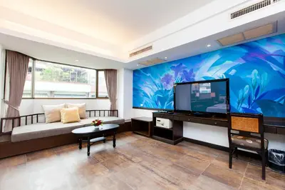 a living room with a large flat screen tv at The Grand Sathorn in Bangkok