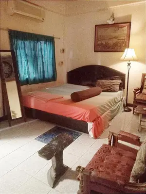 a bedroom with a bed and a window and a chair at Best Guest Bangkok in Bangkok