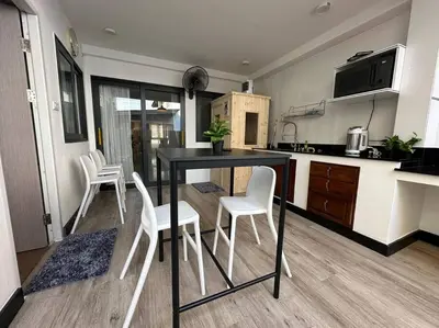 a kitchen with a black table and white chairs at Private cozy house @Chatcuchak in Bang O