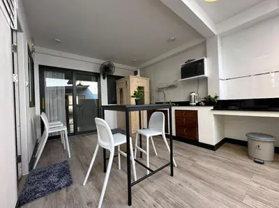 a kitchen with white chairs and a black counter top at Private cozy house @Chatcuchak in Bang O