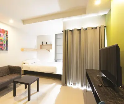 a bedroom with a bed and a tv in a room at Varrzon Residence Srinakarin 56 in Bangna