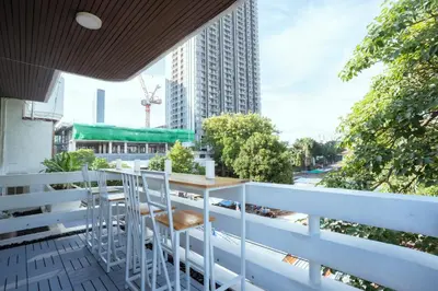 a balcony with a table and chairs on a building at 420 Hostel - Ekkamai Buds & Beds in Bangkok
