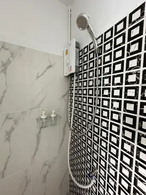a shower in a bathroom with a black and white tile at Bangkok vibe, City House, 7 mins to BTS, City center, Private room in Sathon, Private bathroom, Bangkok, Thailand in Bangkok