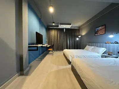 a hotel room with two beds and a television at Chiangmai vibe, City House, 7 mins to BTS, City center, Private room in Sathon, Private bathroom, Bangkok, Thailand in Bangkok