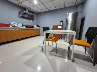 a kitchen with a table and chairs and a refrigerator at Phuket vibe, City House, 7 mins to BTS, City center, Private room in Sathon, Private bathroom, Bangkok, Thailand in Bangkok