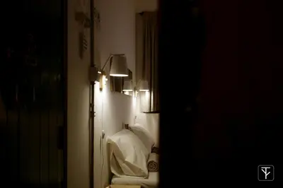 a bathroom with a toilet in a room with lights at T-Boutique Hostel - Hua Lamphong in Bangkok