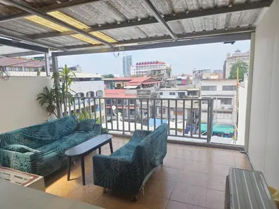 a balcony with couches and a view of a city at Panda Lodge Home Stay in Bangkok