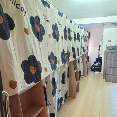 a hallway with a curtain with blue flowers on it at Panda Lodge Home Stay in Bangkok