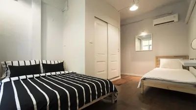 a bedroom with a black and white striped bed and a bench at Cooper in Bangkok