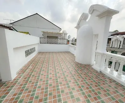 a courtyard of a white house with a brick floor at Private House 3 Suite Beds + Double Beds in Heart of Phromphong in Bangkok