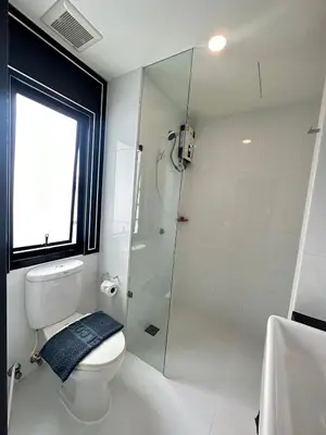 a bathroom with a toilet and a glass shower at 14 Sathorn Hotel in Bangkok