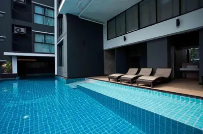 a swimming pool with lounge chairs next to a building at Iconic Hotel in Bangkok