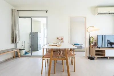 a white dining room with a table and chairs at 2BR, 6 Mins walk BTS Wuttakat in Bangkok