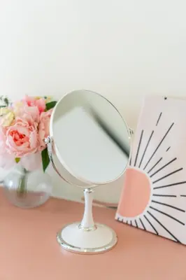 a mirror sitting on a table next to a vase of flowers at 2BR, 6 Mins walk BTS Wuttakat in Bangkok