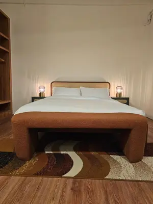 a bed in a bedroom with a rug on the floor at Yaowarat Stay in Bangkok